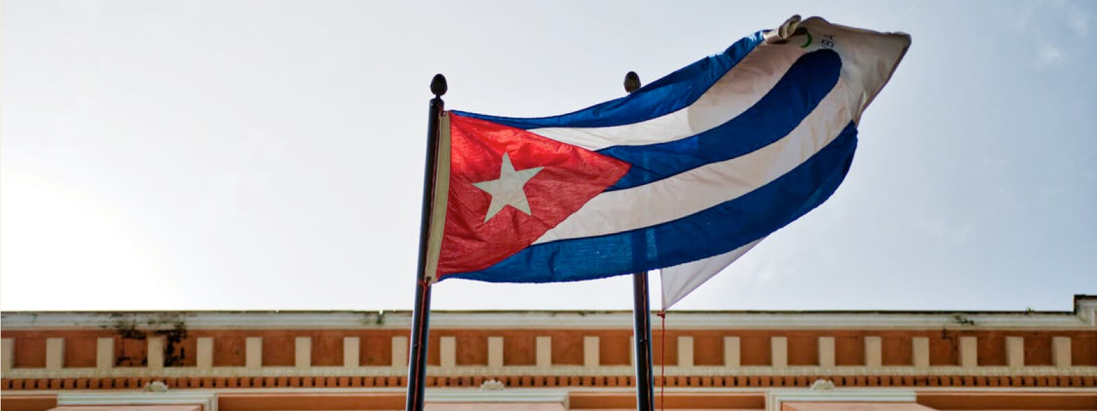 Cuban flag waving against the blue sky.